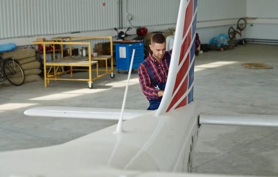 Repairman standing by tail of airplane